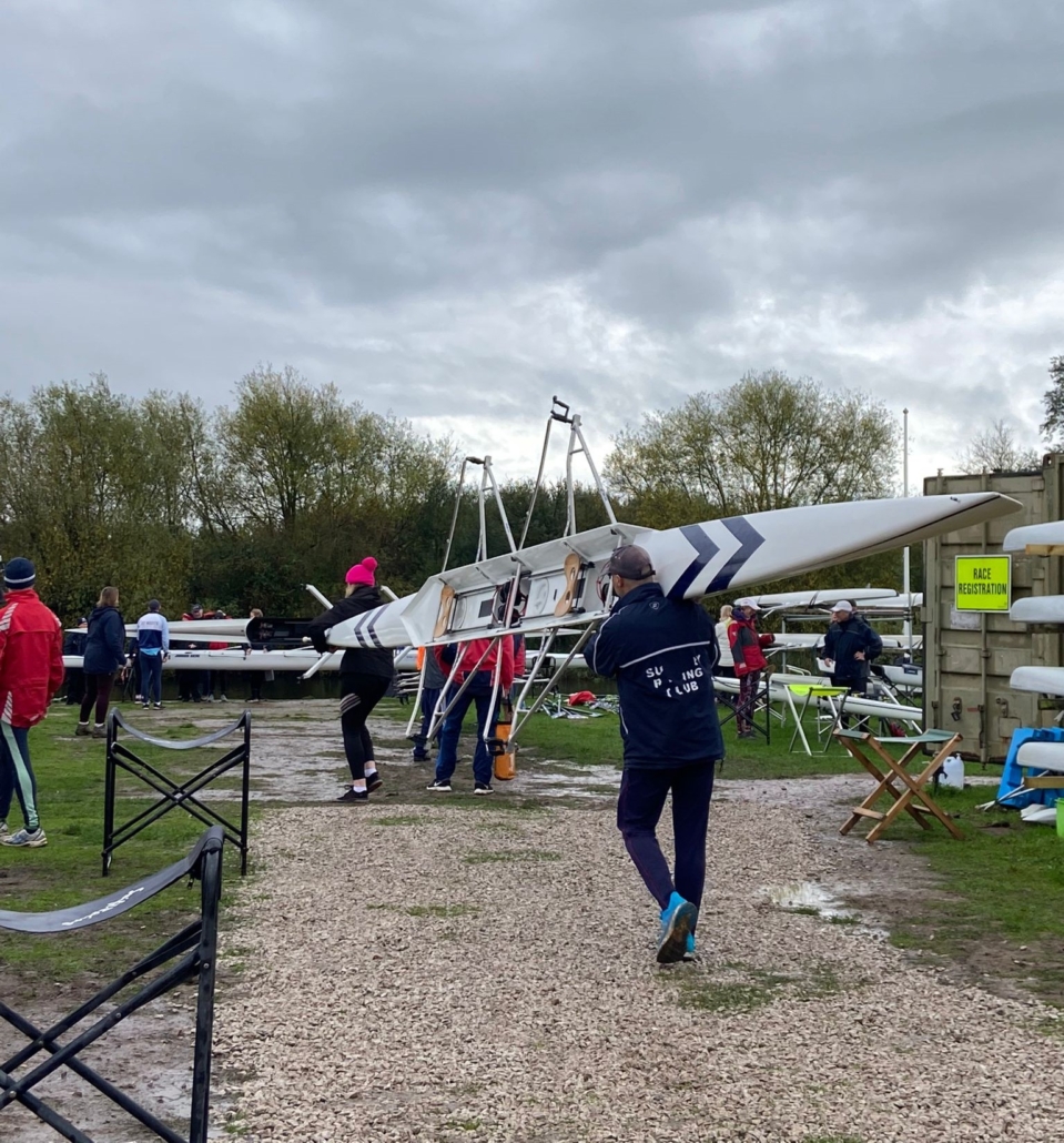 Cropped Rowers carry boats towards river