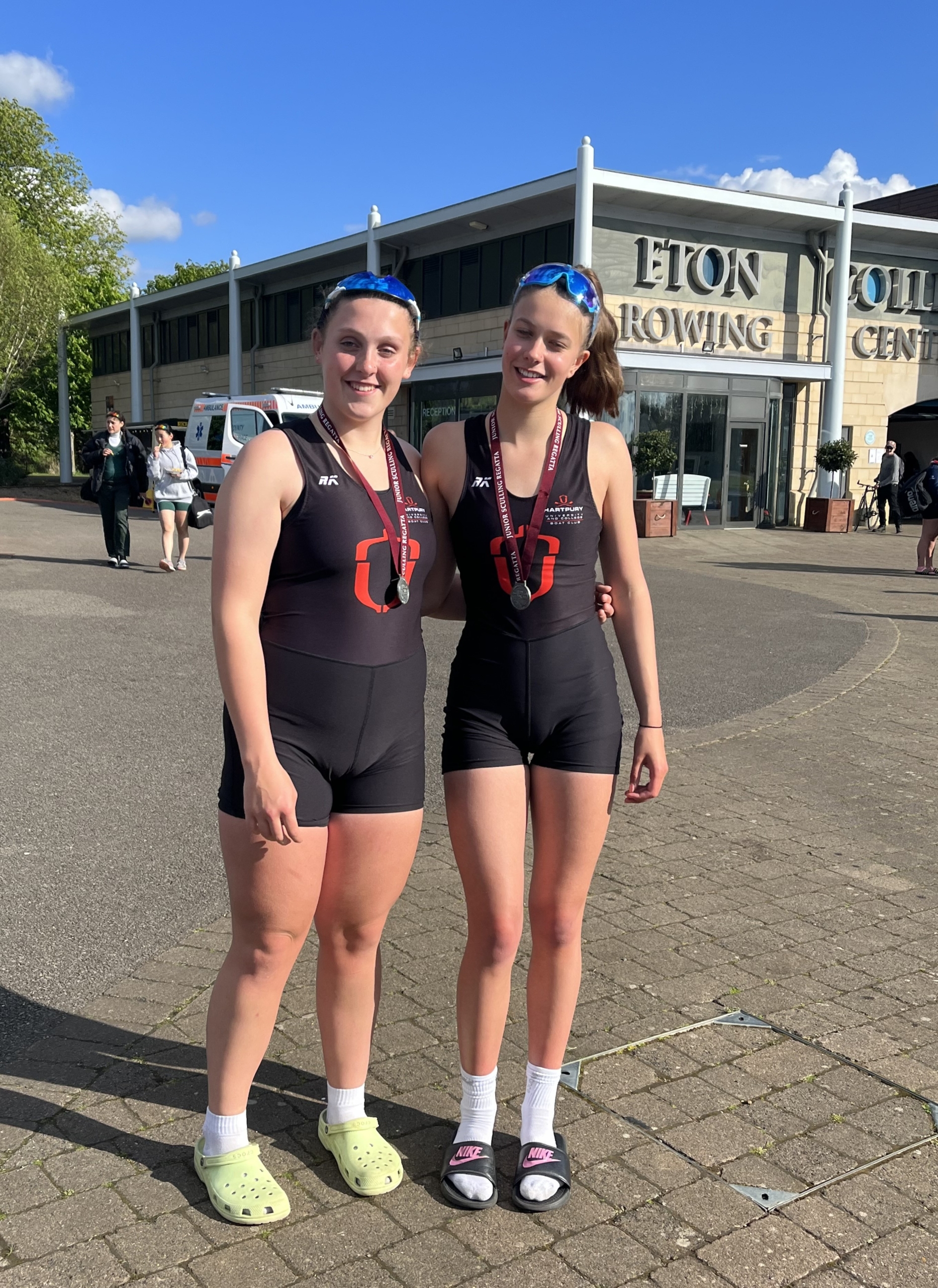 Millie and her double partner stand in the sun with their medals at the Junior Sculling Regatta at Eton Dorney