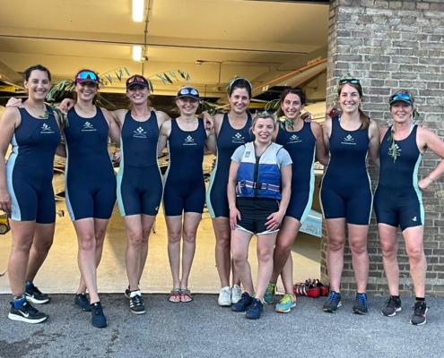 Women's eight crew on land, with willow in their hair