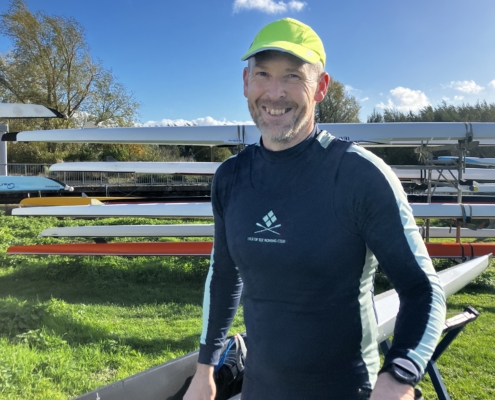 Rower in the sunshine with boats